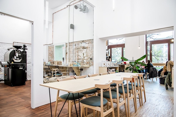Large-wooden-table-and-plpush-chairs-create-a-smart-dining-and-workshop-area-inside-the-coffee-shop.jpg